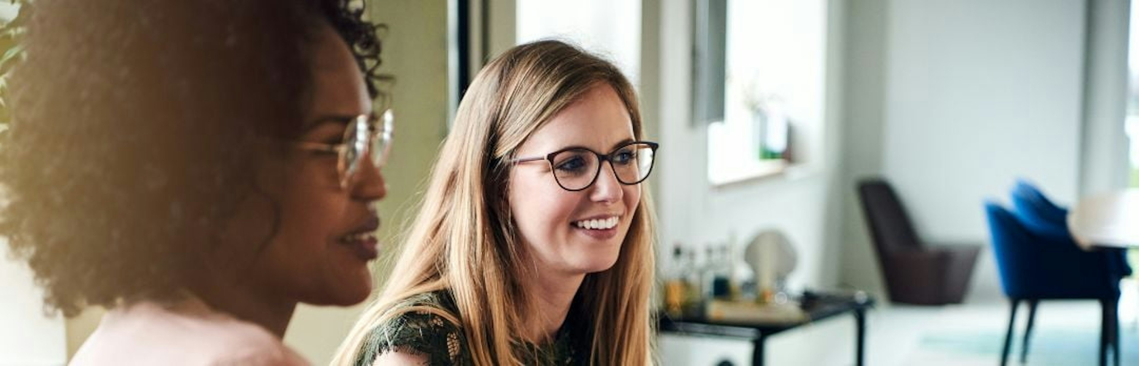 2 female coworkers smiling together in a recruitment meeting about cultural fit and flexibility