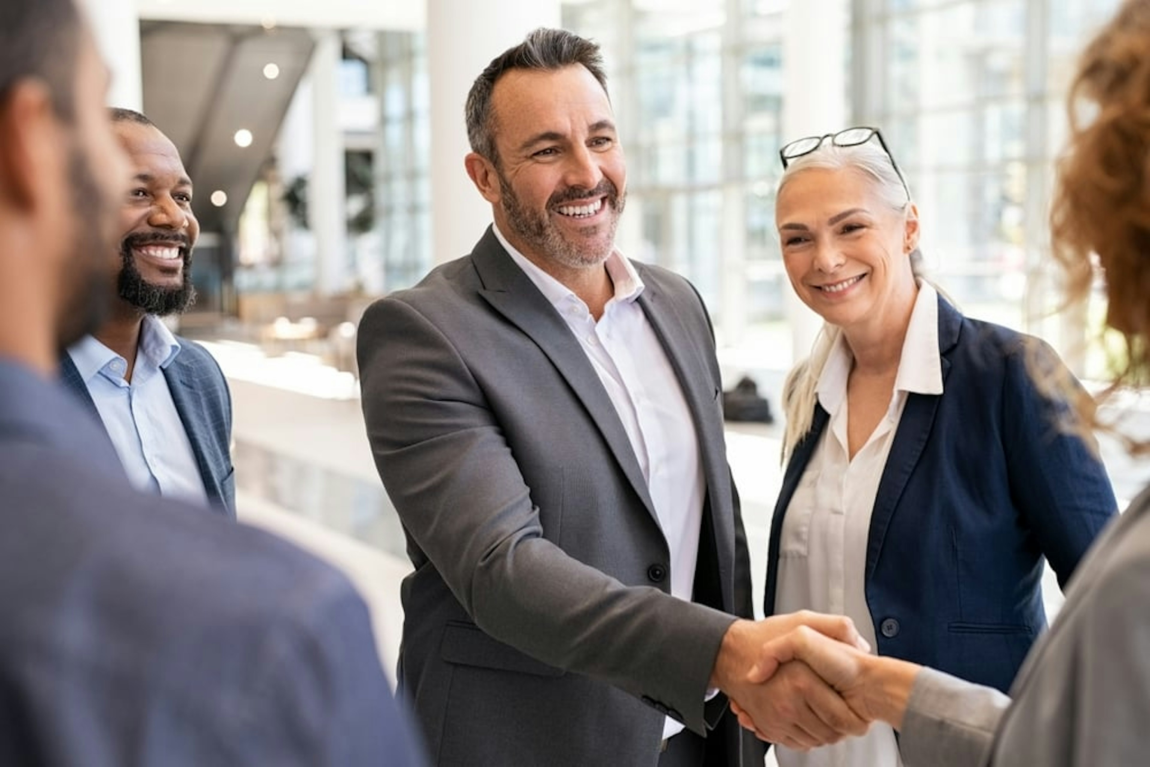 Business executives smiling and shaking hands in a group